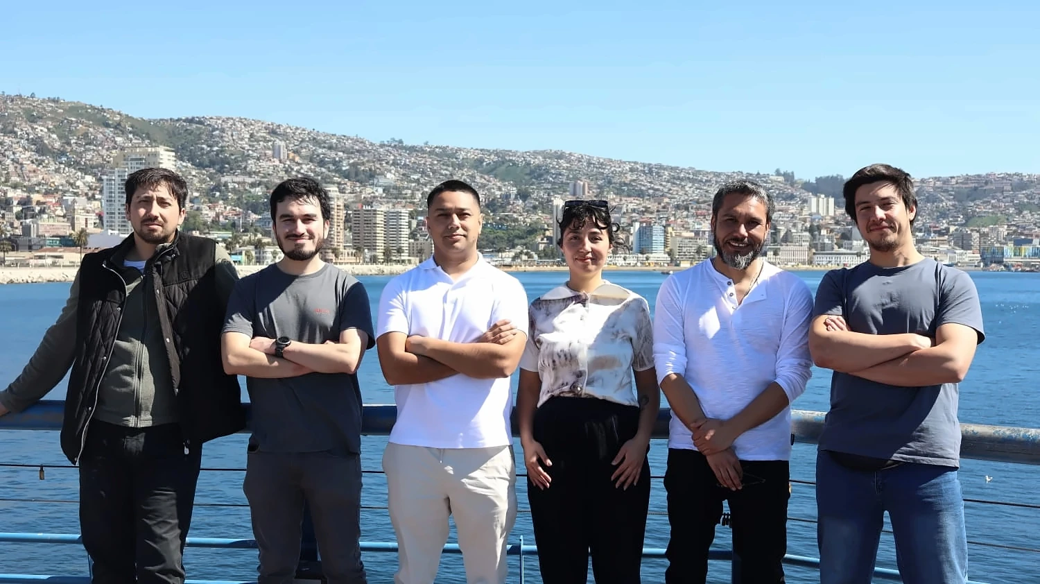 Equipo de RedOcean en el muelle de Valparaíso, con los cerros de la ciudad de fondo.